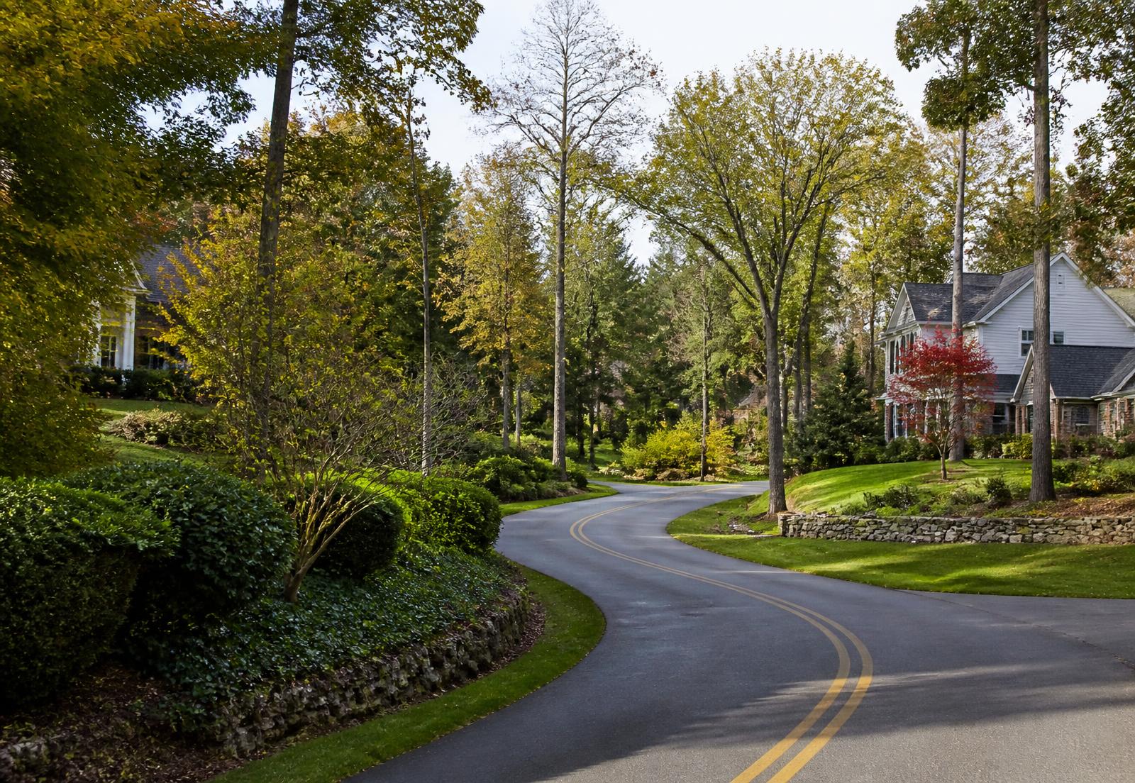 Tree-lined North Fulton residential road with spacious lawns and mature landscaping